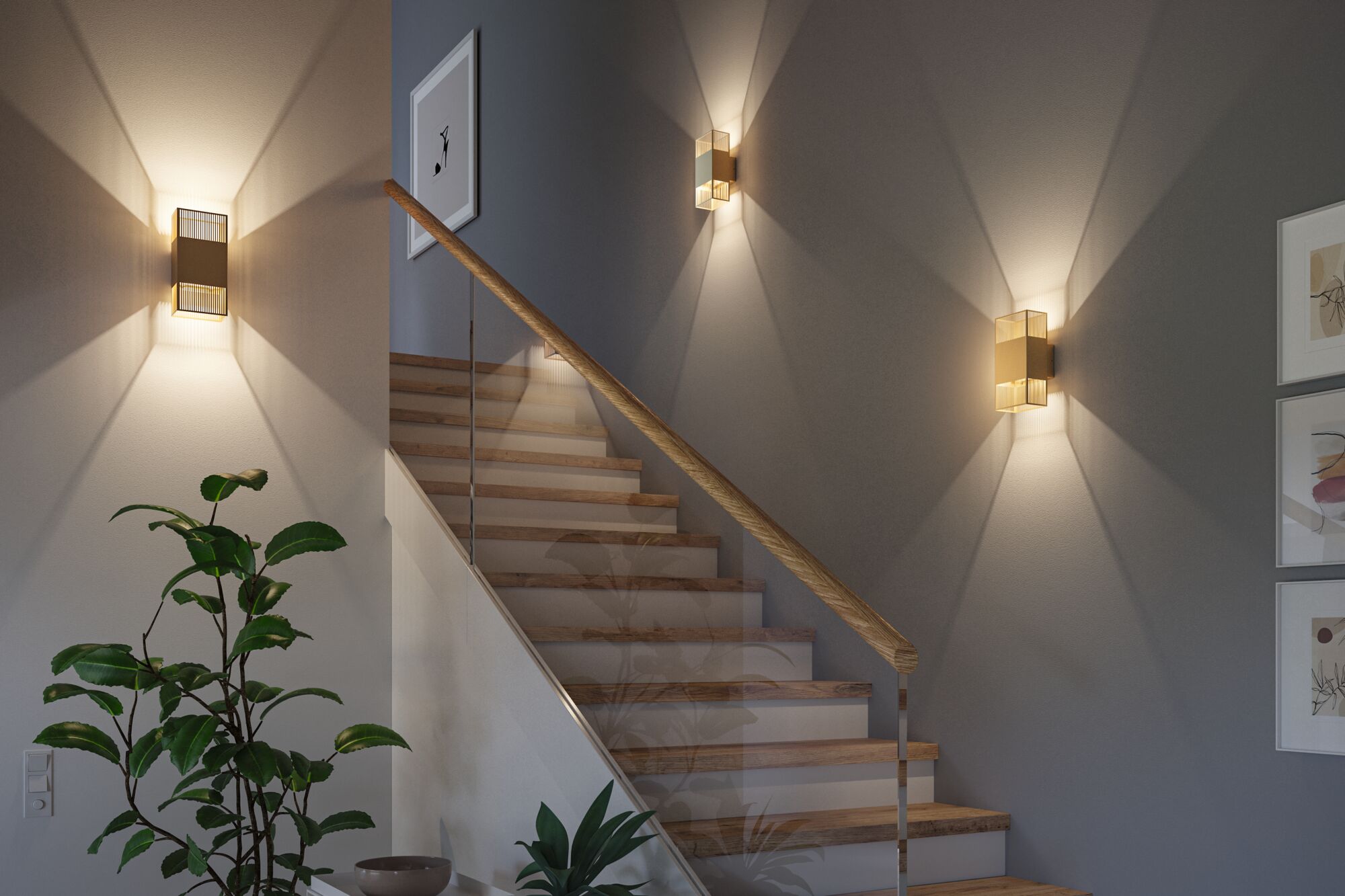 Moderne goldfarbene Wandleuchten aus Metall an Treppenwand mit warmem Licht und Holzgeländer