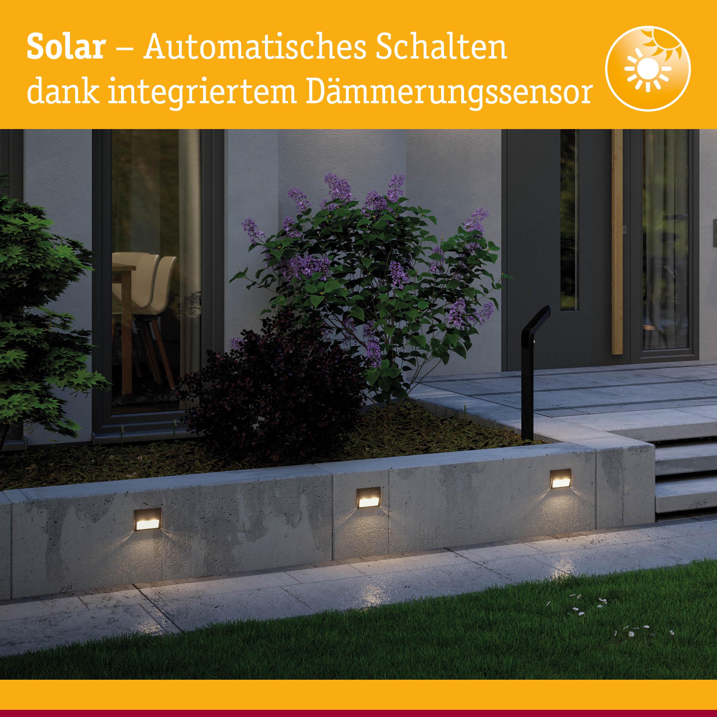 Solarbetriebene Außenwandleuchten mit integriertem Dämmerungssensor an grauer Betonmauer im Garten