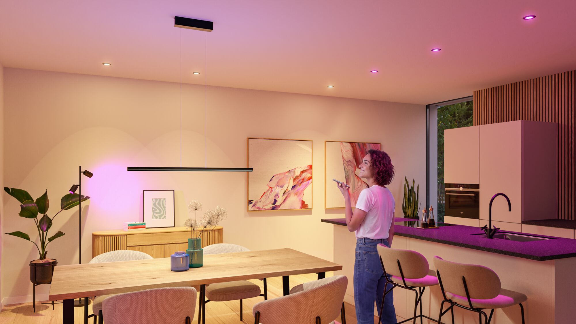 Modern kitchen featuring smart LED ceiling and pendant lights with warm white and purple hues.