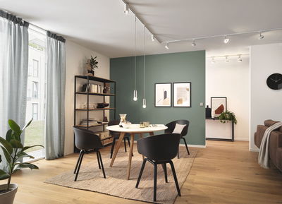 Moderner Essbereich mit runden Holztisch, schwarzen Stühlen und minimalistischer LED-Deckenbeleuchtung