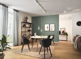 Modern dining area with round wooden table, black chairs, and minimalist LED ceiling lighting