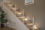 Moderne Holztreppe mit weißen Stufen und warmweißen LED-Wandlichtern für stimmungsvolle Treppenbeleuchtung