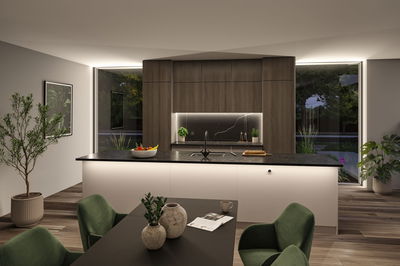 Modern kitchen with wood cabinets, black countertop and indirect LED lighting for ambient home lighting.