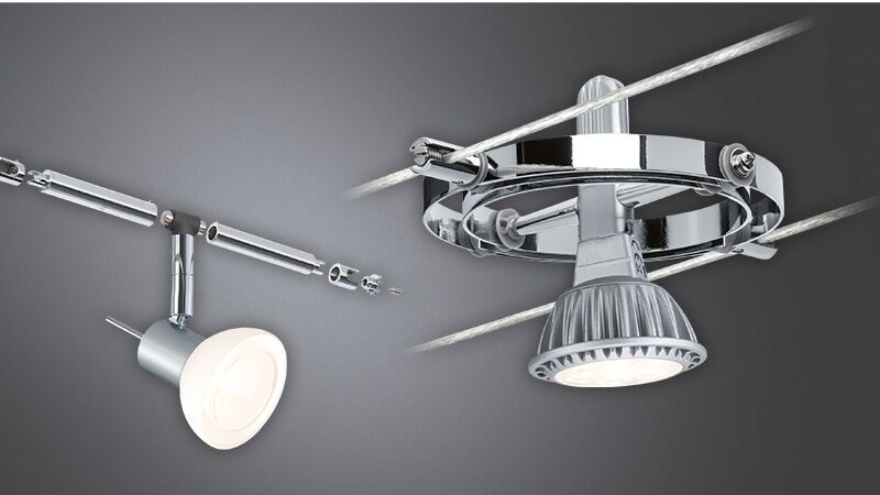 Spots LED chromés sur système de câbles avec lampes réglables pour éclairage flexible.
