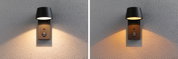 Black metal outdoor wall light with motion sensor and warm white light on grey textured wall
