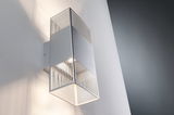 Modern silver metal wall light with vertical slats and warm white light for indoor lighting