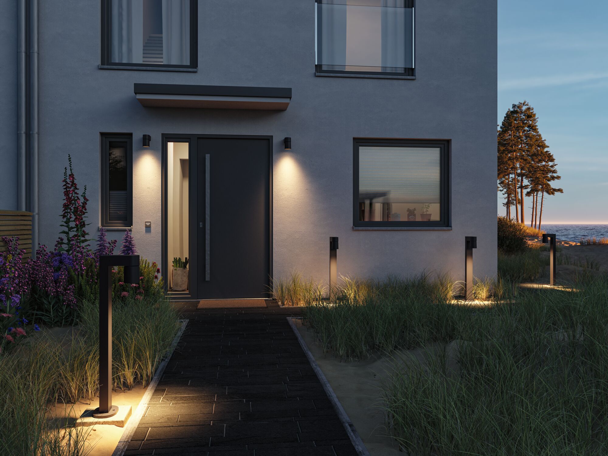 Modern house with black front door and warm white metal outdoor lights along path and facade.