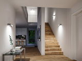 Modern hallway with wooden stairs and white walls illuminated by minimalist LED wall lights.