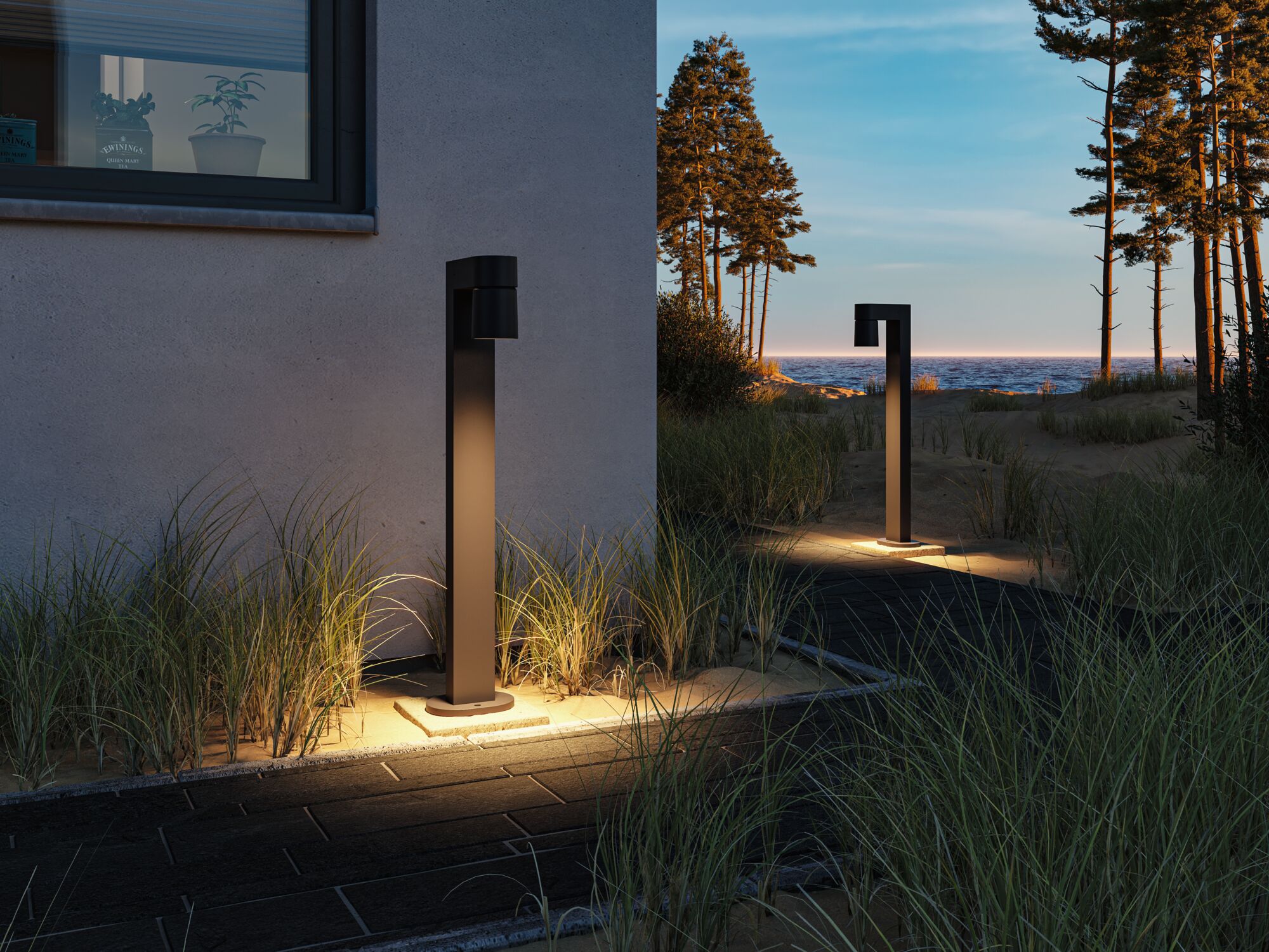 Moderne schwarze Außenleuchte aus Metall beleuchtet Gartenweg bei Dämmerung mit Meerblick.