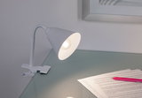 Witte metalen klemlamp met flexibele hals op glazen oppervlak, geschikt voor bureauverlichting.