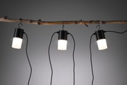 Trois suspensions LED noires avec diffuseur blanc suspendues à une branche, éclairage intérieur moderne.