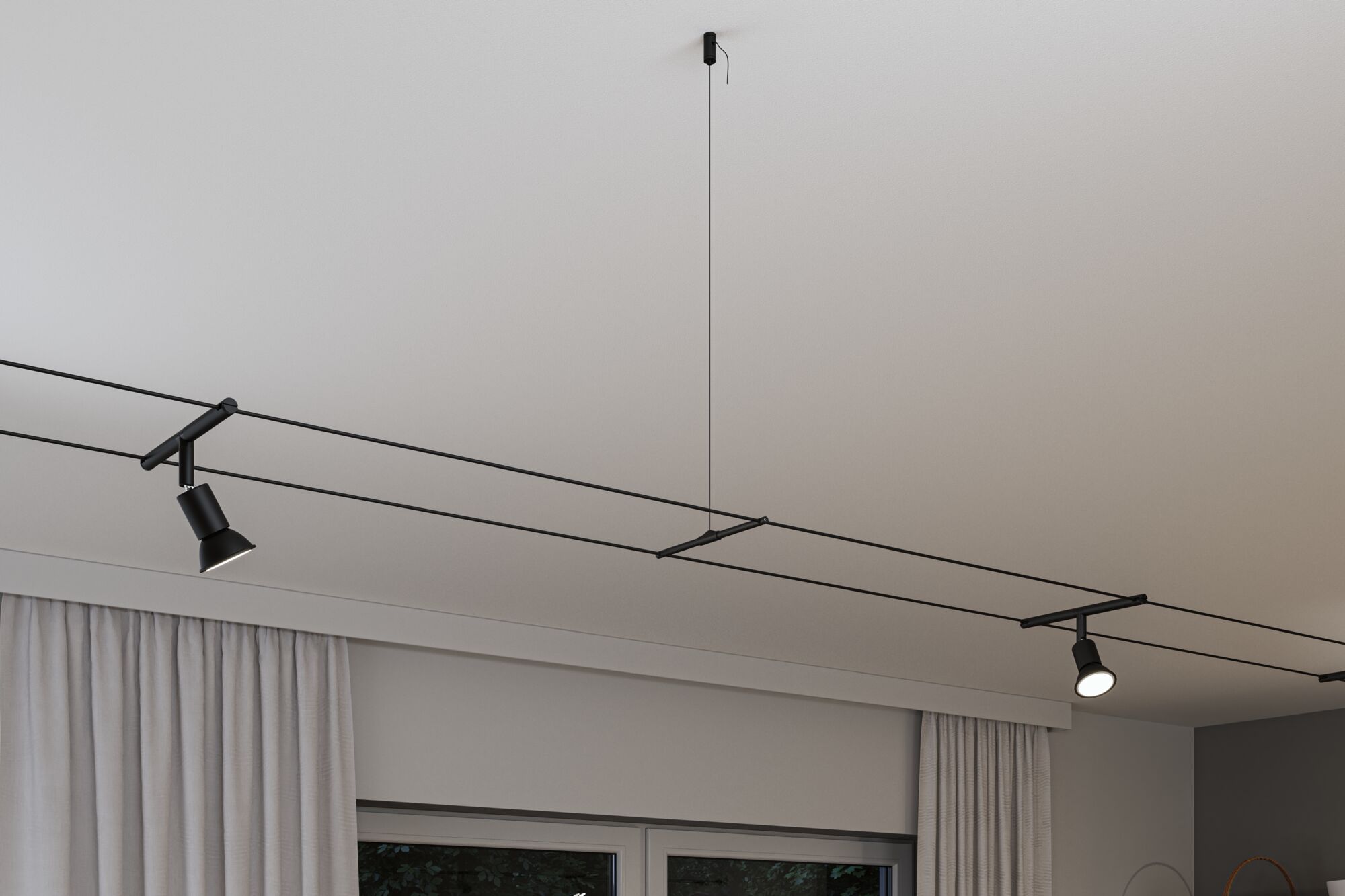 Black minimalist cable lighting system with two adjustable spotlights on white ceiling for modern room lighting