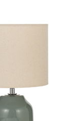 Table lamp with green ceramic base and beige fabric shade for ambient lighting
