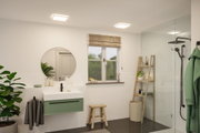 Salle de bain moderne avec plafonniers carrés blancs, meuble-lavabo vert et douche en verre