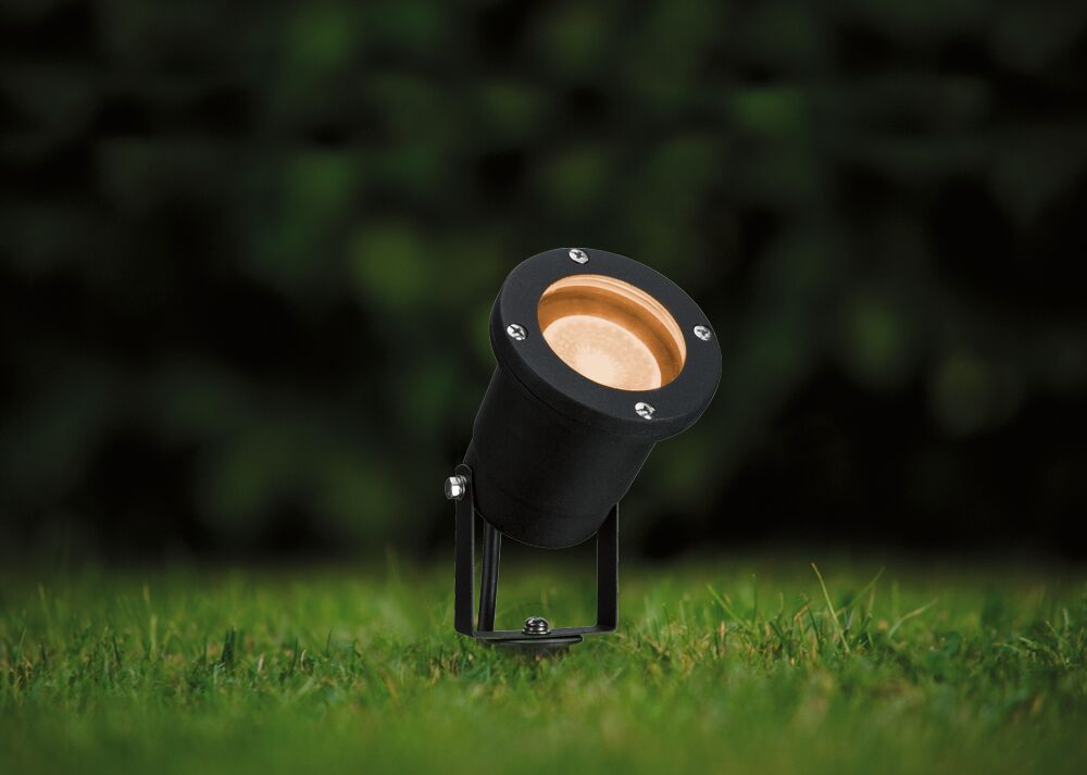 Schwarzer Outdoor-Strahler aus Metall mit warmweißem Licht auf grünem Rasen für Gartenbeleuchtung