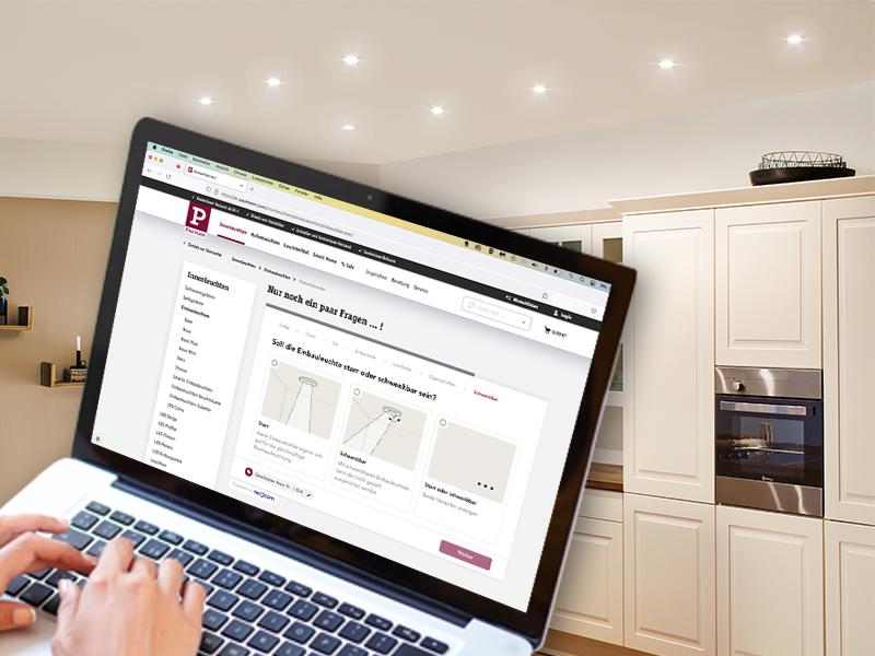 Ordinateur portable affichant le guide d'achat Paulmann dans une cuisine moderne avec éclairage encastré et LED au plafond