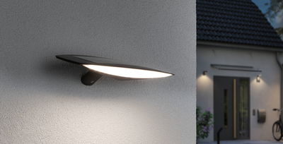 Zwarte LED buitenmuurlamp met brede lichtstraal gemonteerd aan gevel voor moderne buitenverlichting