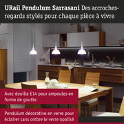 Trois suspensions en verre blanc au-dessus d'une table en bois dans une cuisine moderne avec meubles en bois