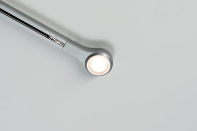 Modern silver metal ceiling spotlight with round LED head for ambient room lighting