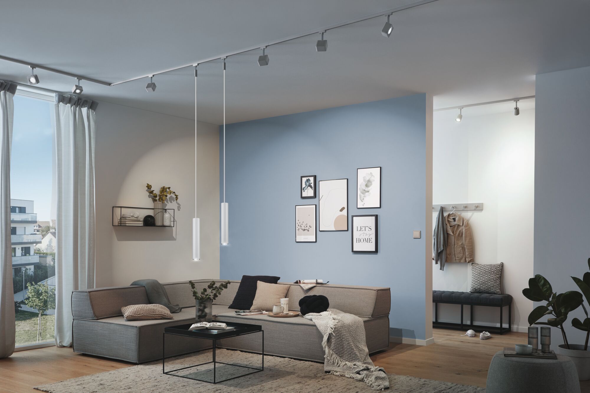 Moderne woonkamer met grijze stoffen bank, blauwe accentmuur en minimalistische LED-plafondverlichting.