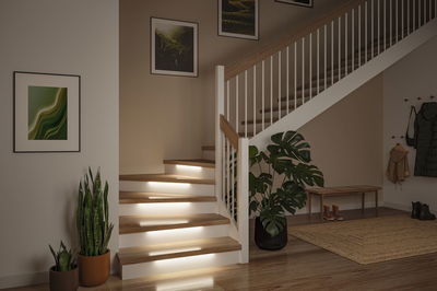 Modern staircase with wooden steps and integrated LED step lighting for safe stairway illumination.