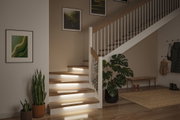 Moderner Treppenaufgang mit Holzstufen und integrierter LED-Stufenbeleuchtung für sicheres Treppenhaus.