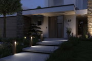 Moderne udendørsbelysning med varm hvid LED-træpæle ved indgang til hus med stenvæg