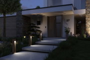 Modern outdoor lighting with warm white LED wooden bollards at house entrance with stone wall