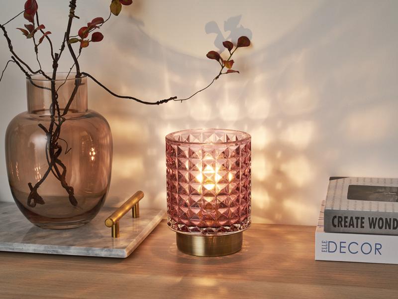 Lyserød glasbordlampe med geometrisk mønster og messingfod, dekorativ stemningsbelysning.