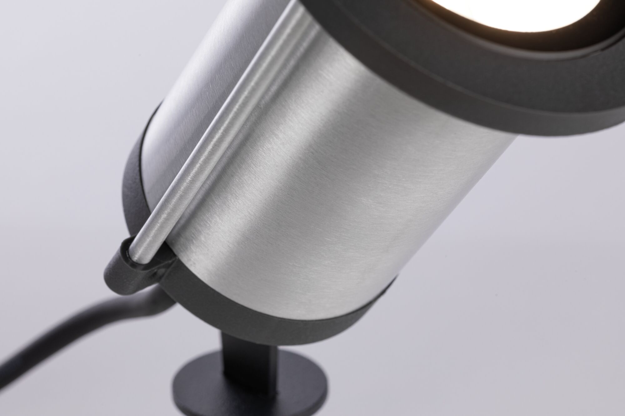 Nahaufnahme eines silbernen Aluminium-Strahlers mit schwarzem Sockel und Kabel für Innenbeleuchtung
