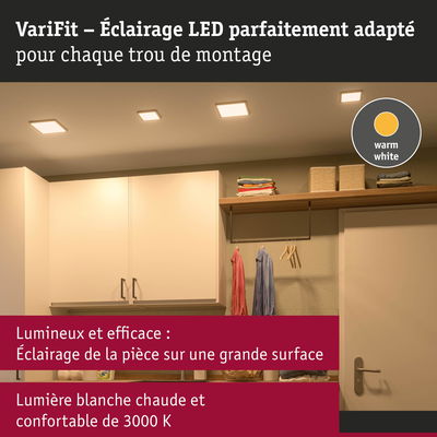 Éclairage LED blanc chaud au plafond d’une pièce moderne avec placards et vêtements suspendus