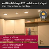 Éclairage LED blanc chaud au plafond d’une pièce moderne avec placards et vêtements suspendus