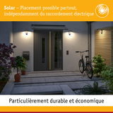 Appliques murales extérieures solaires grises à l'entrée d'une maison avec vélo et plantes au crépuscule