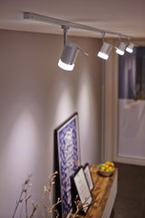Lumière sur rail LED blanche moderne avec quatre spots réglables dans un salon décoré.