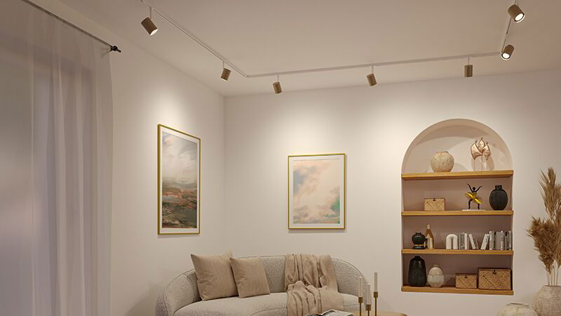 Living room with cream sofa, beige cushions and modern white ceiling spotlights for ambient lighting