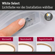 Finger stellt Lichtfarbe an weißem Kunststoffschalter ein, LED-Deckenleuchte mit Holzring in Warmweiß, Neutralweiß, Tageslichtweiß
