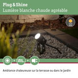 Projecteur extérieur noir avec lumière blanche chaude sur gravier pour terrasse et jardin