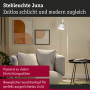Weiße Stehleuchte Juna mit beweglichem Leuchtenkopf neben beigem Sofa und abstrakter Wandkunst