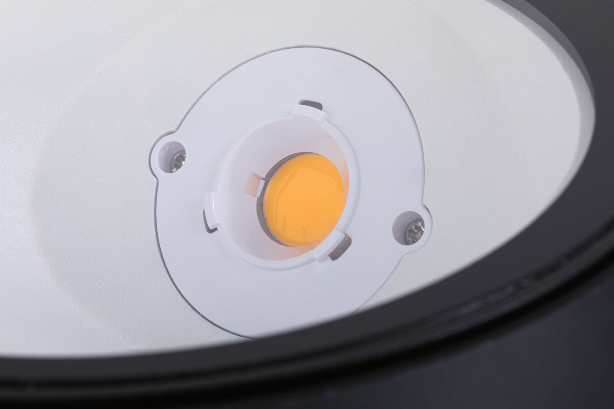Nahaufnahme einer weißen LED-Lichtquelle mit orangefarbenem Leuchtmittel im Lampengehäuse