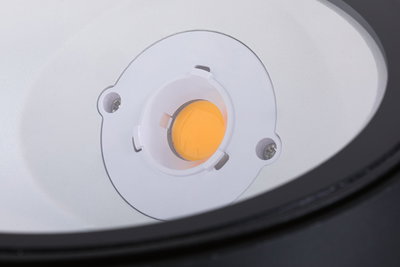 Nahaufnahme einer weißen LED-Lichtquelle mit orangefarbenem Leuchtmittel im Lampengehäuse