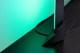 Schwarze LED-Standleuchte mit grünem Licht auf dunklem Holztisch für moderne Raumbeleuchtung