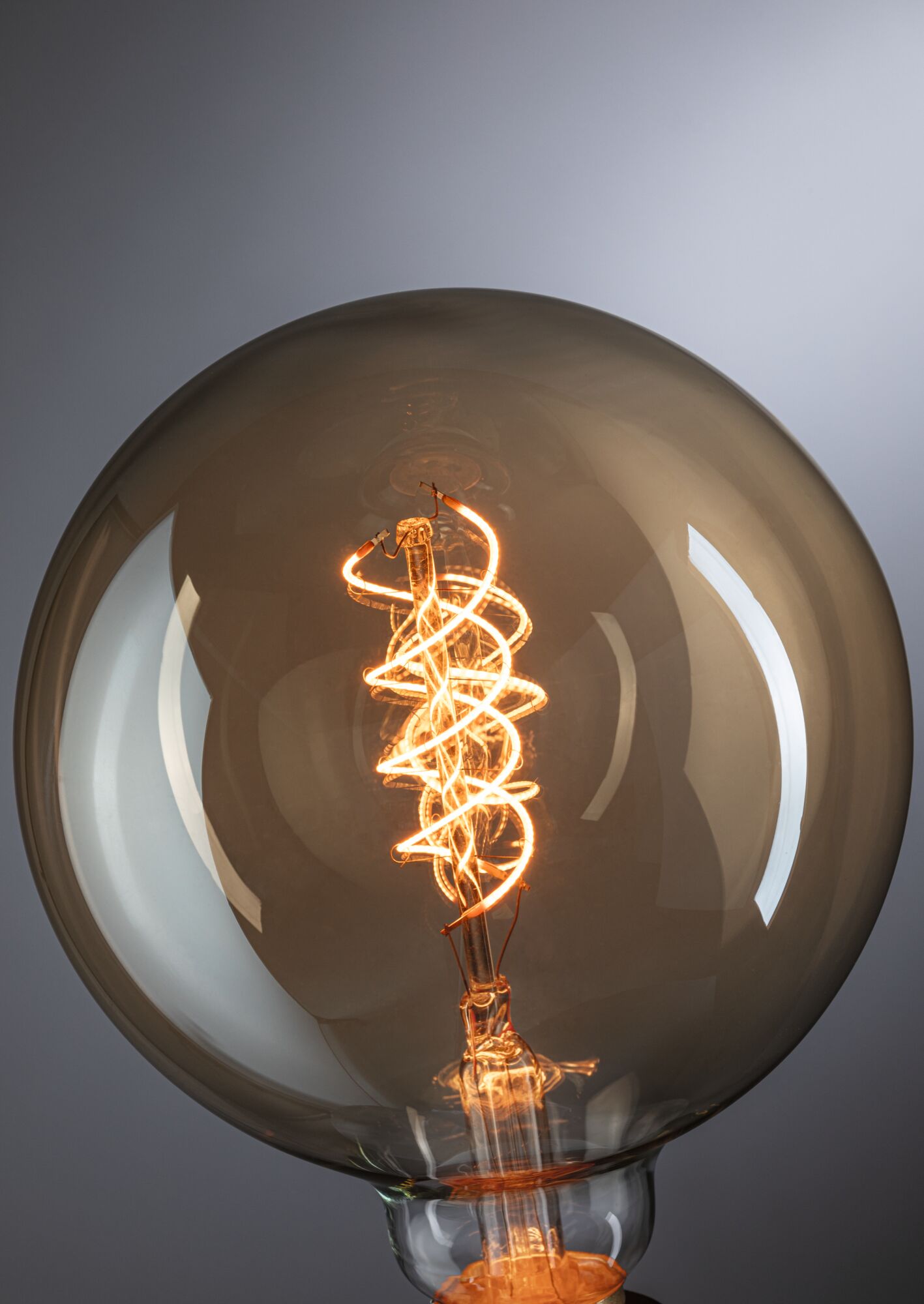 Stor pære med spiralformet LED-filament i varm ravfarve til dekorativ belysning