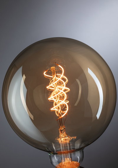 Large light bulb with spiral LED filament in warm amber for decorative lighting and ambiance