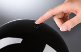 Hand tippt auf schwarzen glänzenden Schalter mit Power-Symbol für moderne LED-Beleuchtung