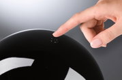 Hand tippt auf schwarzen glänzenden Schalter mit Power-Symbol für moderne LED-Beleuchtung