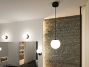 Moderne Pendel- und Wandlampen mit weißen Glaskugeln und schwarzem Metall in stilvollem Badezimmer.