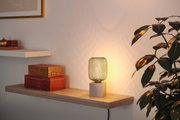 Modern table lamp with grey metal cube base and decorative wire shade casting warm light