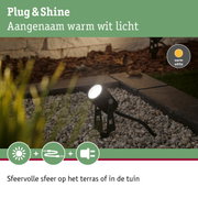 Zwarte buitenspot met warm wit licht op grind voor sfeervolle tuinverlichting