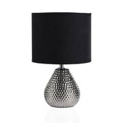 Tafellamp met zwarte stoffen kap en zilveren, gehamerde metalen voet voor modern interieur