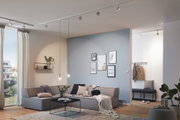 Modern living room with grey corner sofa, black pendant lights, and minimalist blue and white wall decor